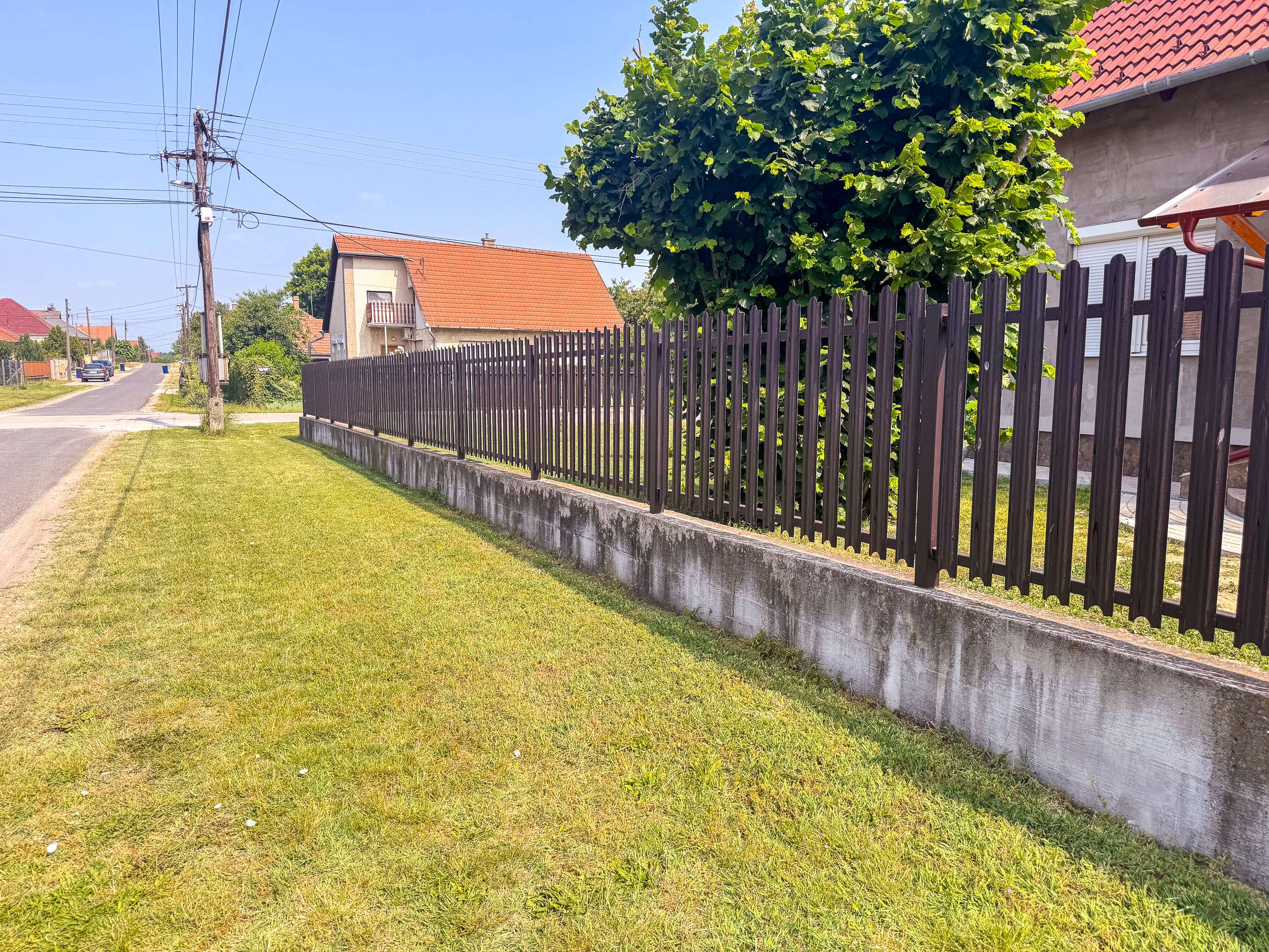 Hosszú utcafronti fém kerítés – famintás kerítésléc